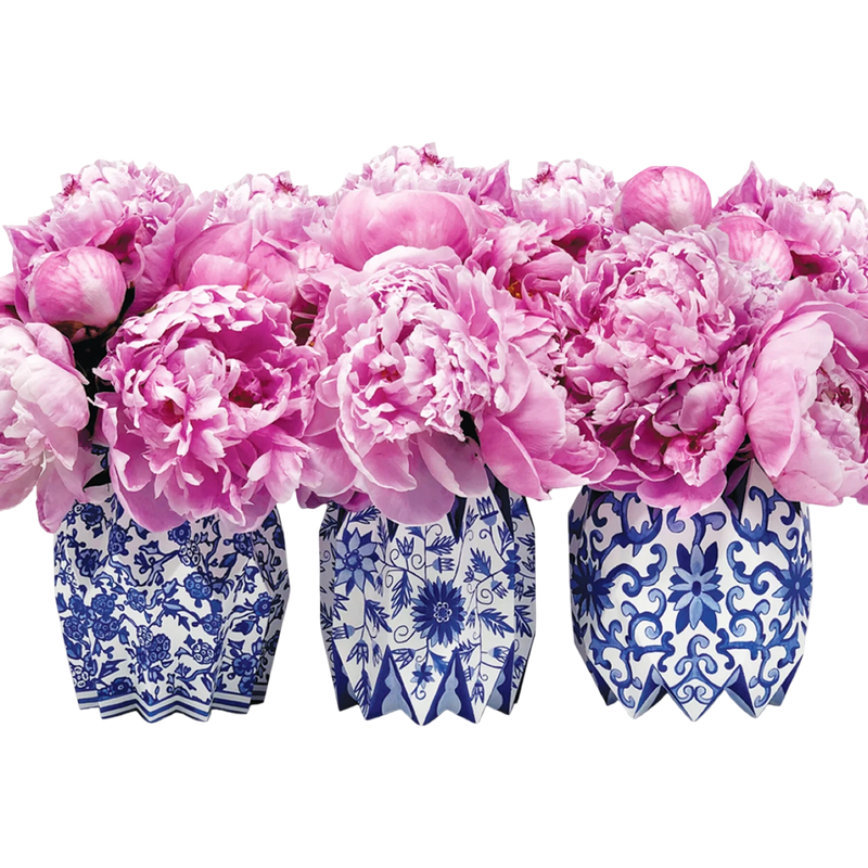 Pink flowers in blue and white patterned vases on a white background