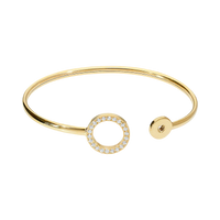 Gold bracelet with a circular design and small stones on a white background