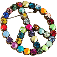 Multicolored jeweled peace sign brooch on a white background