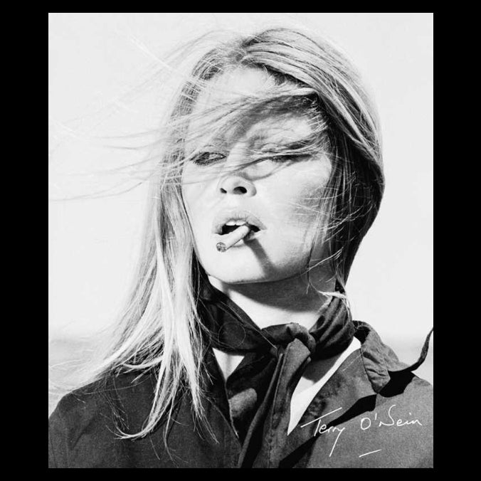 Black and white portrait of a woman with a cigarette, wearing a coat and scarf.