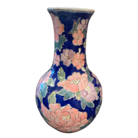 A ceramic vase with a dark blue glaze decorated with large pink flowers and green leaves, shown against a plain white background.