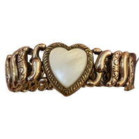 A vintage-style gold-tone chain bracelet featuring a central heart-shaped inlay with a pearlescent white mother-of-pearl finish, set against a plain white background.