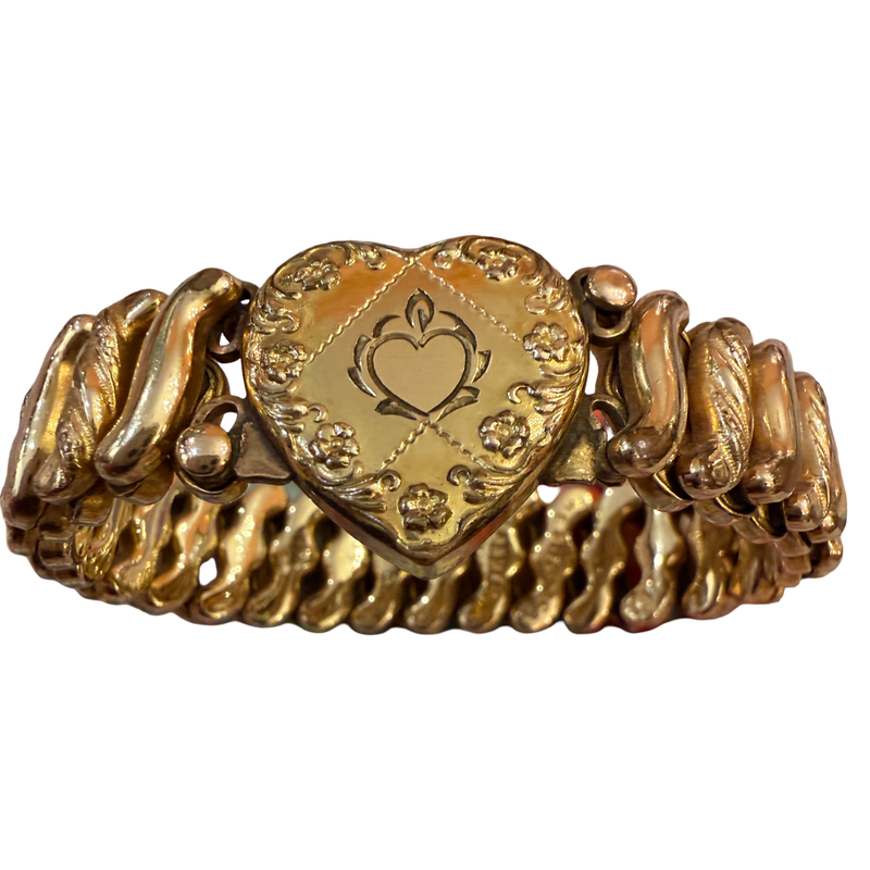 A vintage gold heart-shaped bracelet with a central engraved heart medallion and textured, wavy side bands, shown on a plain white background.
