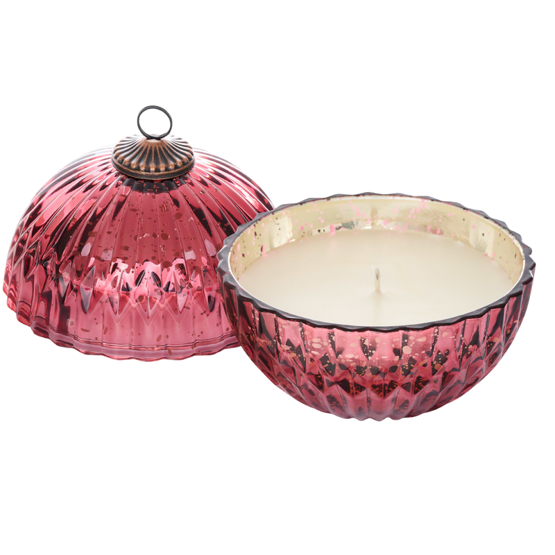 Pink textured candle holder with a candle inside on a white background