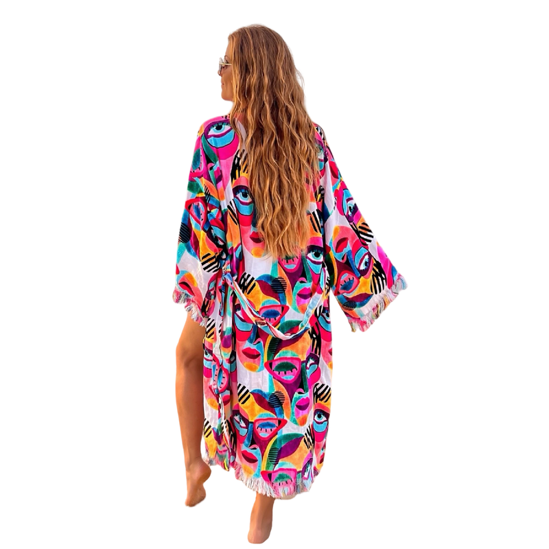 Woman wearing colorful Karli Buxton Picasso print organic cotton kaftan on the beach

