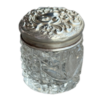 Decorative glass jar with a silver lid on a white background