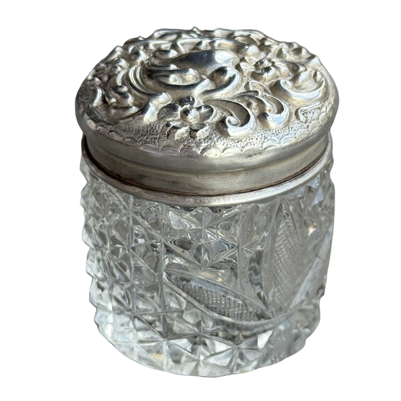 Decorative glass jar with a silver lid on a white background