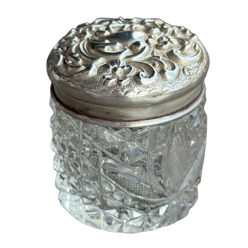 Decorative glass jar with a silver lid on a white background