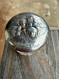 Close-up of a silver decorative button on a wooden surface
