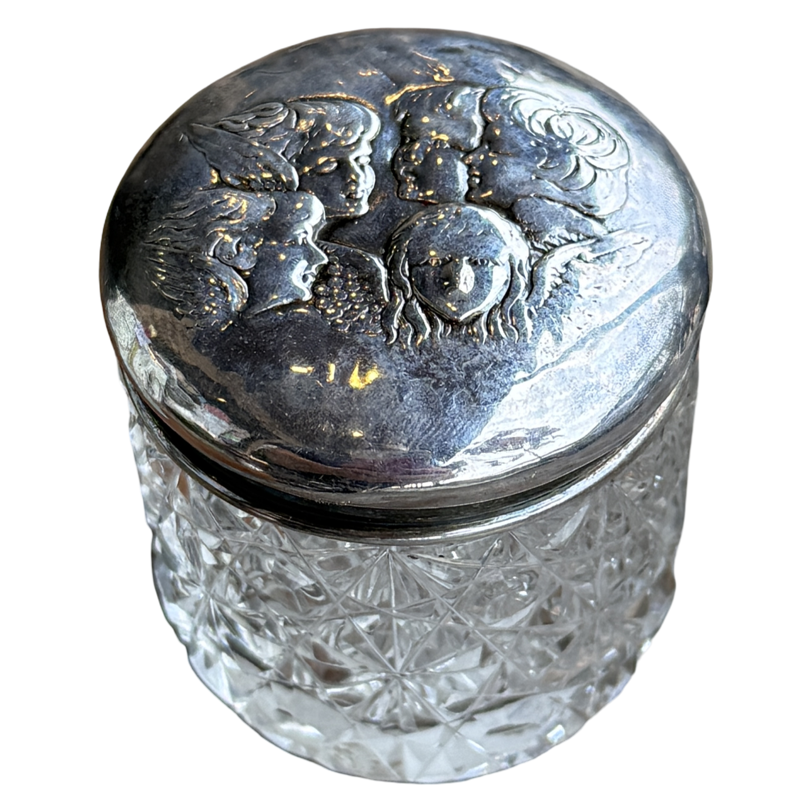 Decorative glass jar with silver lid featuring engraved faces on a white background