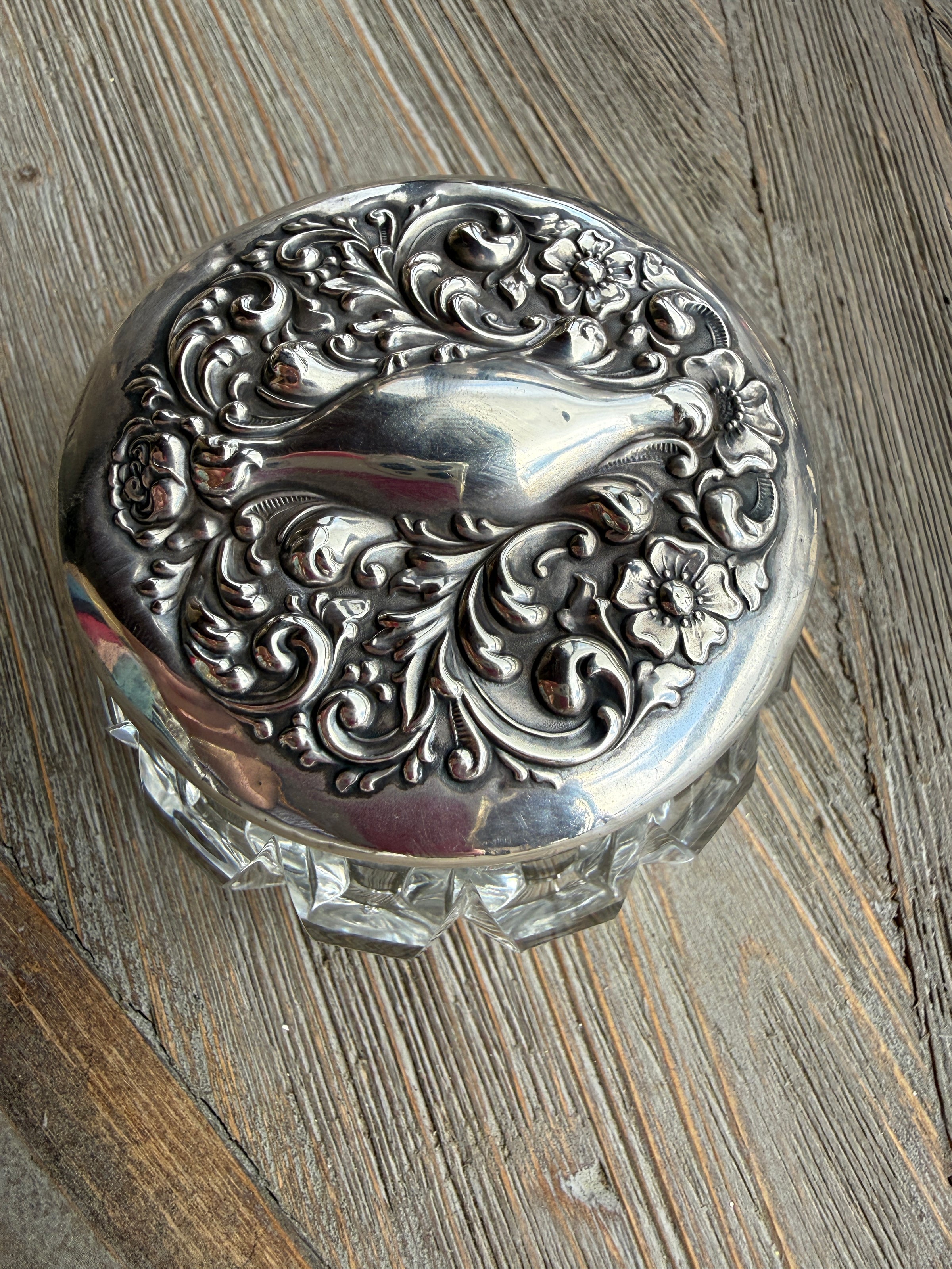 Decorative silver trinket box on a wooden surface