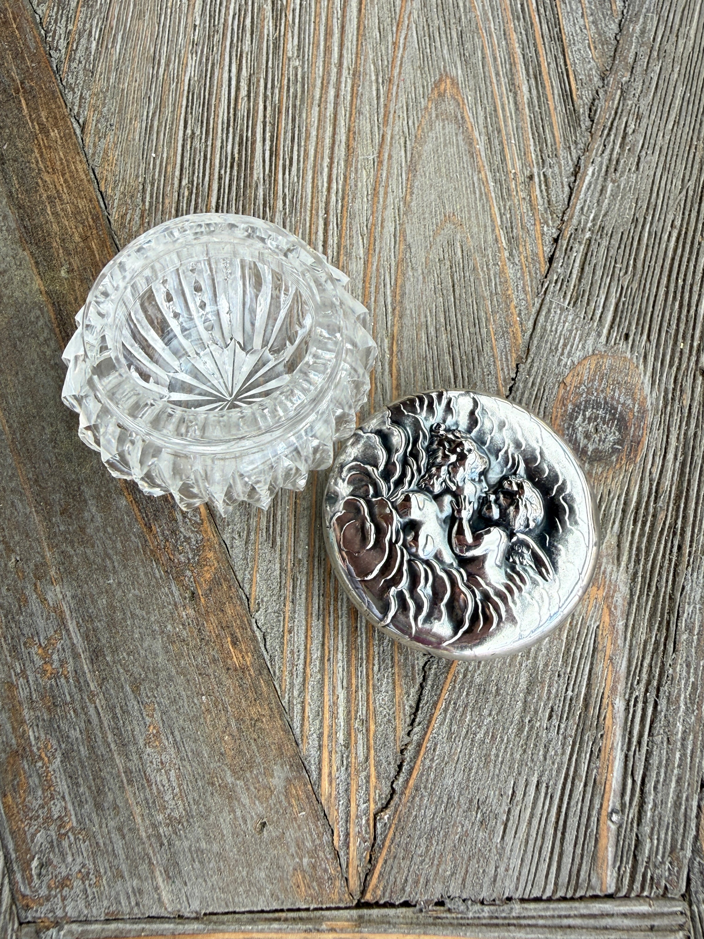 Silver decorative object with intricate design on a wooden surface