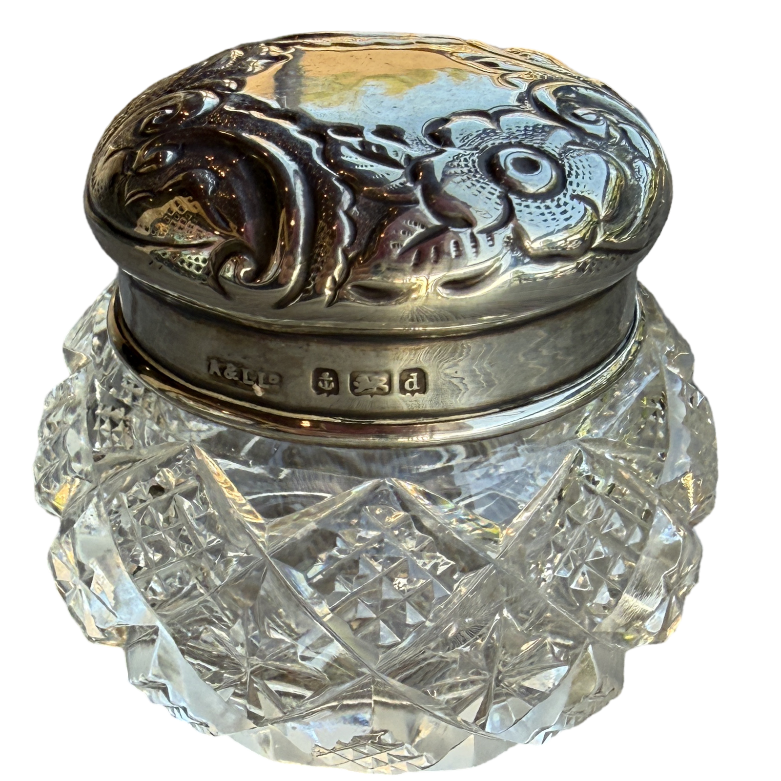 Decorative glass jar with silver lid on a white background