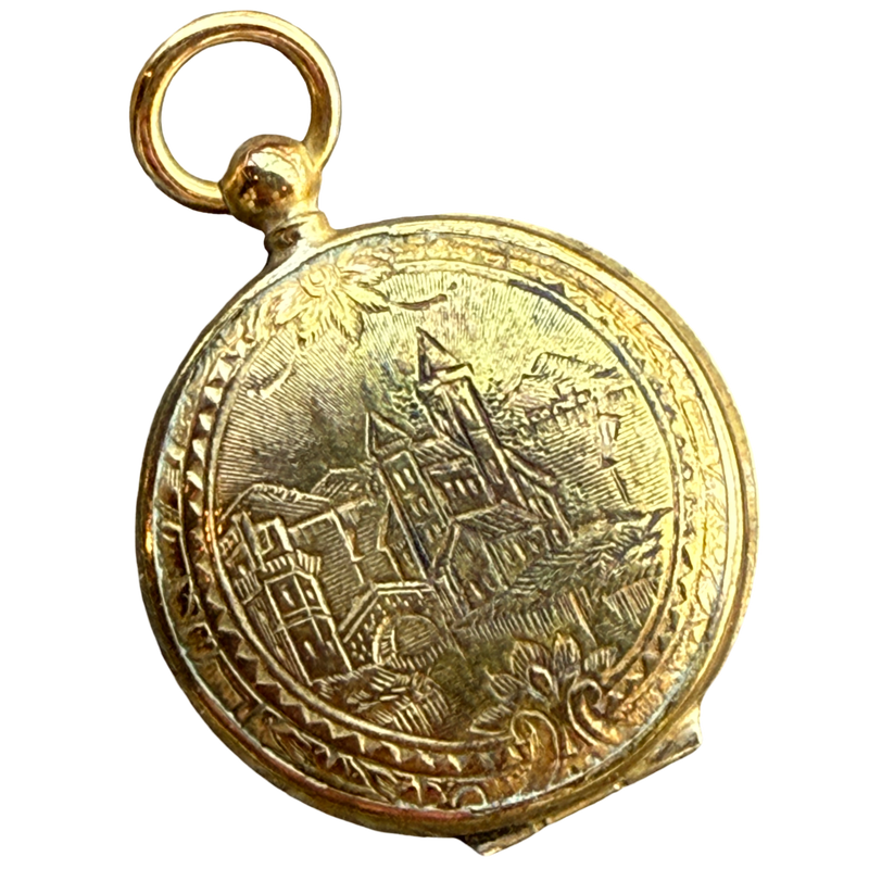 Gold locket with engraved design on a white background