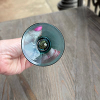 Hand holding a wine glass with a blurred background