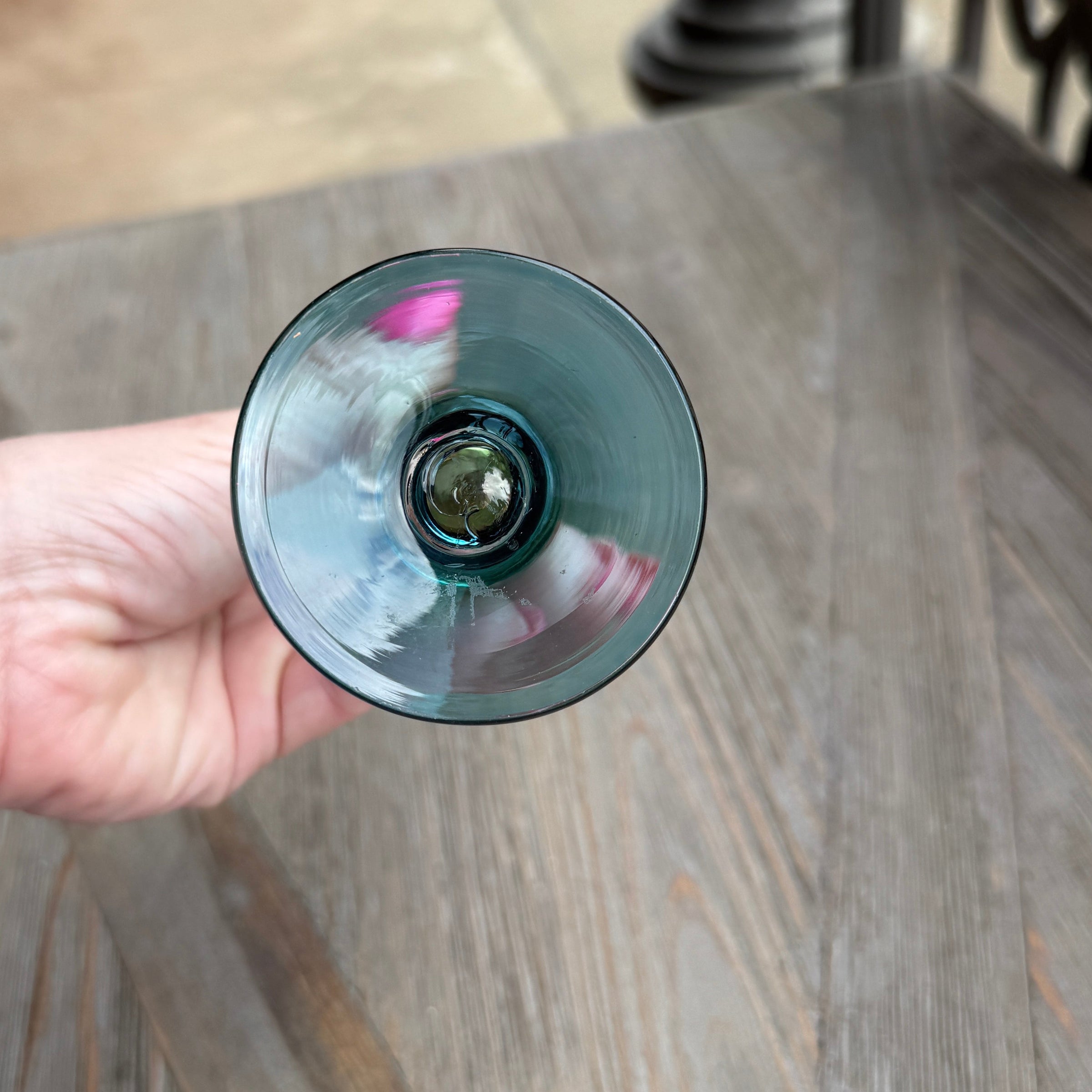 Hand holding a wine glass with a blurred background