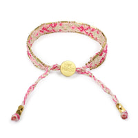 Floral patterned bracelet with a gold charm on a white background