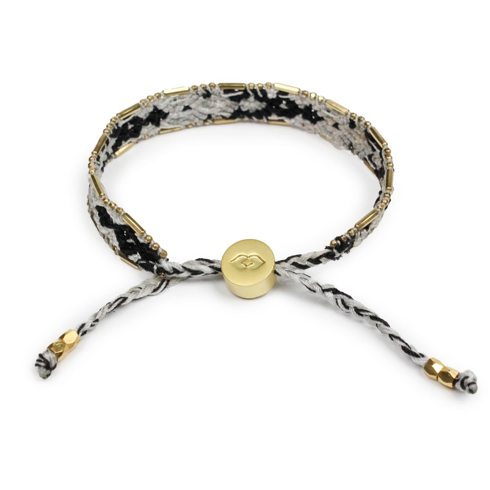 Bracelet with black and white pattern and gold accents on a white background