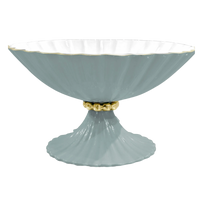 Light blue decorative bowl with gold base on a white background