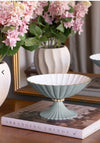 Decorative bowl on a book with flowers in the background