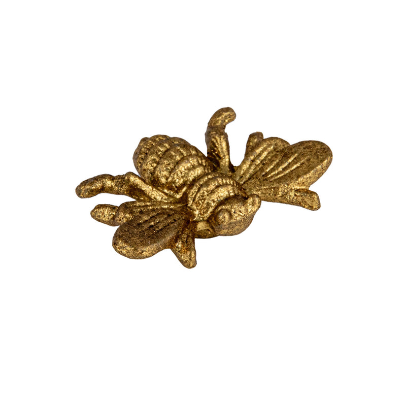 Gold bee-shaped decorative object on a white background
