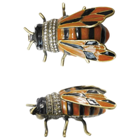 Two bee-shaped pins with rhinestone details on a white background