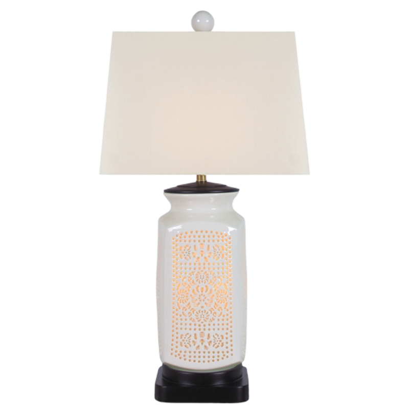 Table lamp with white textured base and cream lampshade on a white background