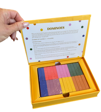 boxed dominoes game, tabletop dominoes set, stylish dominoes gift, classic domino game, colorful wooden dominoes, gold foil domino set, family game night essentials, design-focused dominoes, giftable board games, modern domino set