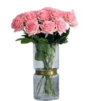 Bouquet of pink roses in a clear vase on a white background