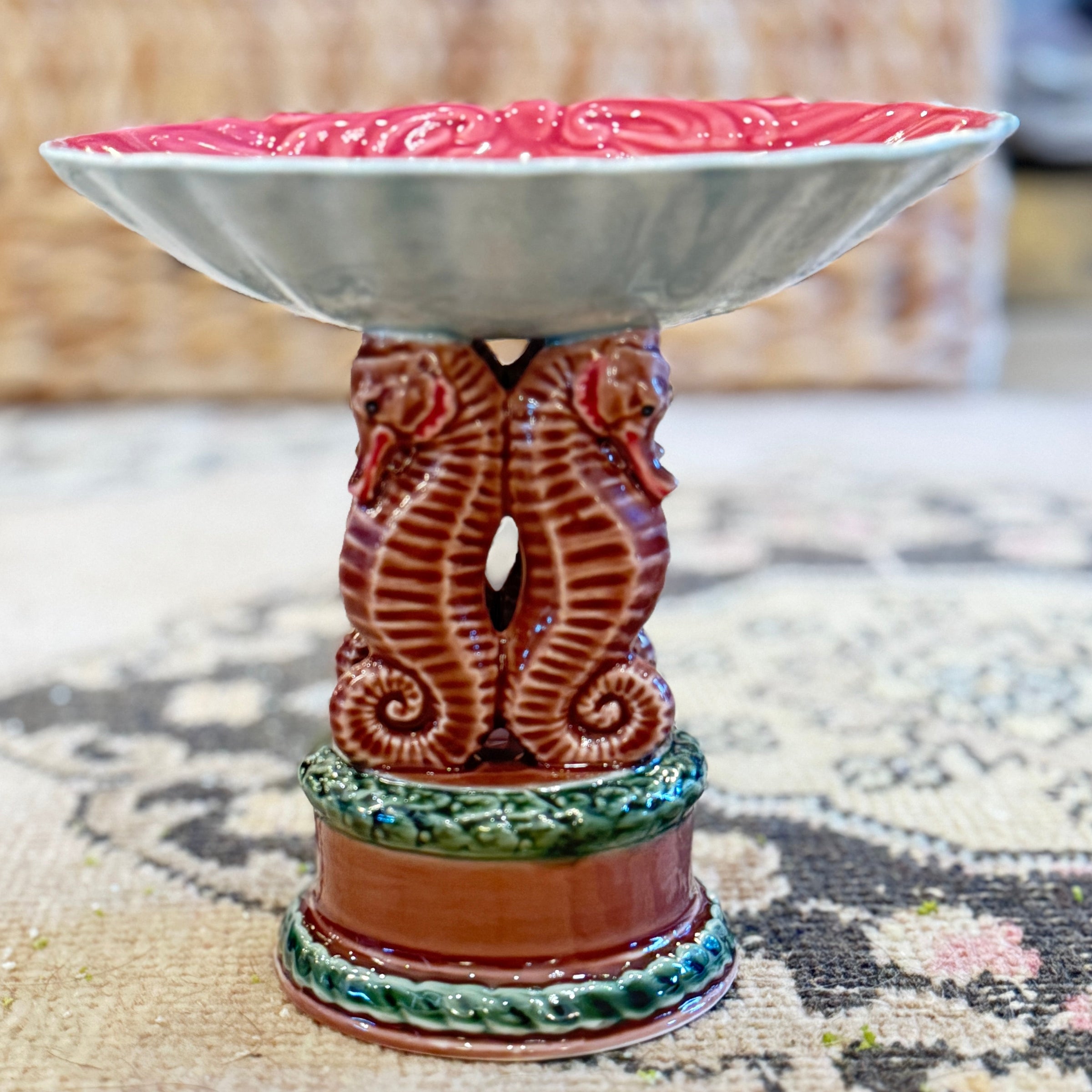 Decorative ceramic bowl with a red rim on a patterned surface