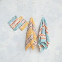 Set of colorful knitted towels on a light gray background
