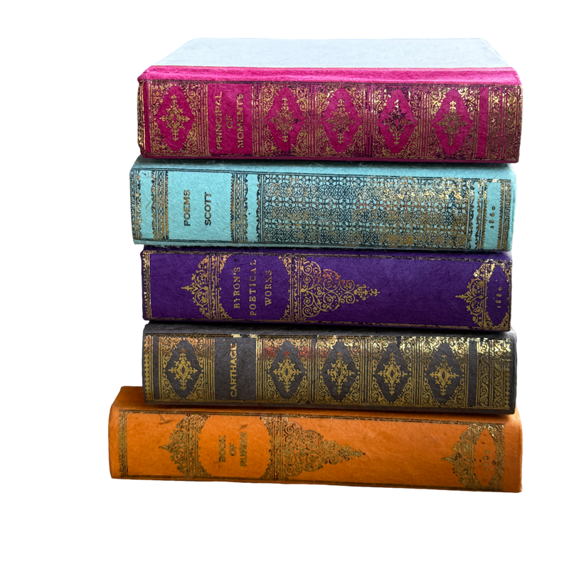 Five ornate books with decorative spines on a white background