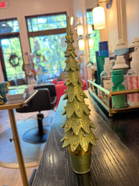 Decorative gold object on a wooden surface with a blurred indoor background