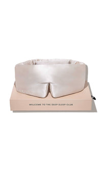 White sleep mask on a pink box with 'The Deep Sleep Club' branding on a white background