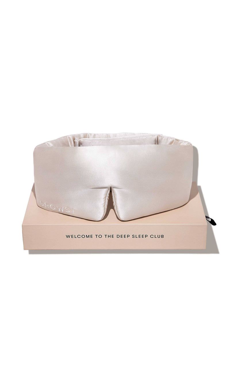 White sleep mask on a pink box with 'The Deep Sleep Club' branding on a white background