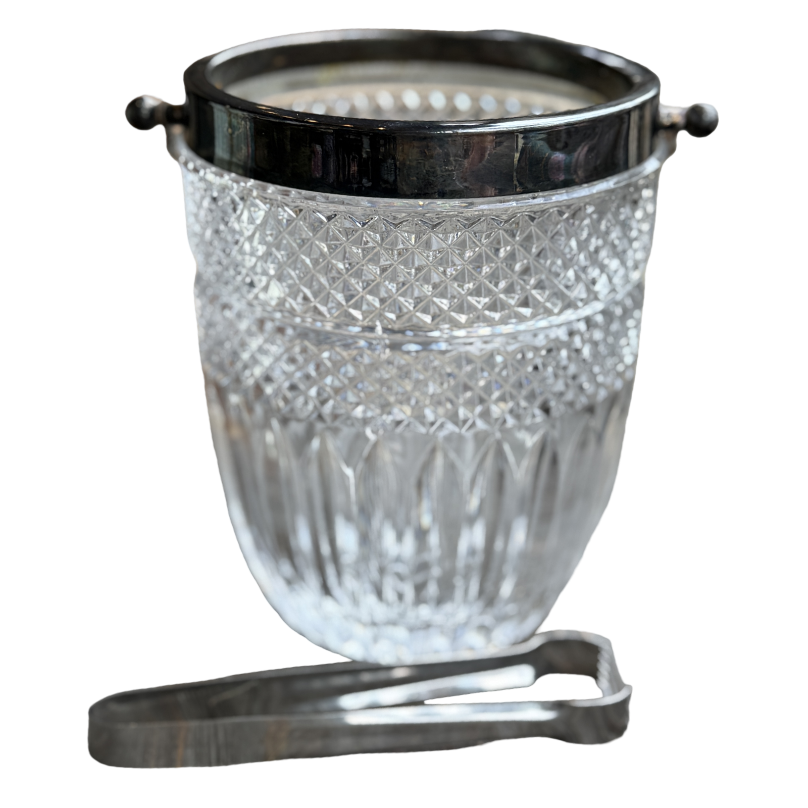 Clear glass ice bucket with black lid and silver tongs on a white background