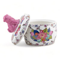Decorative ceramic pot with floral design and pink lid on a white background