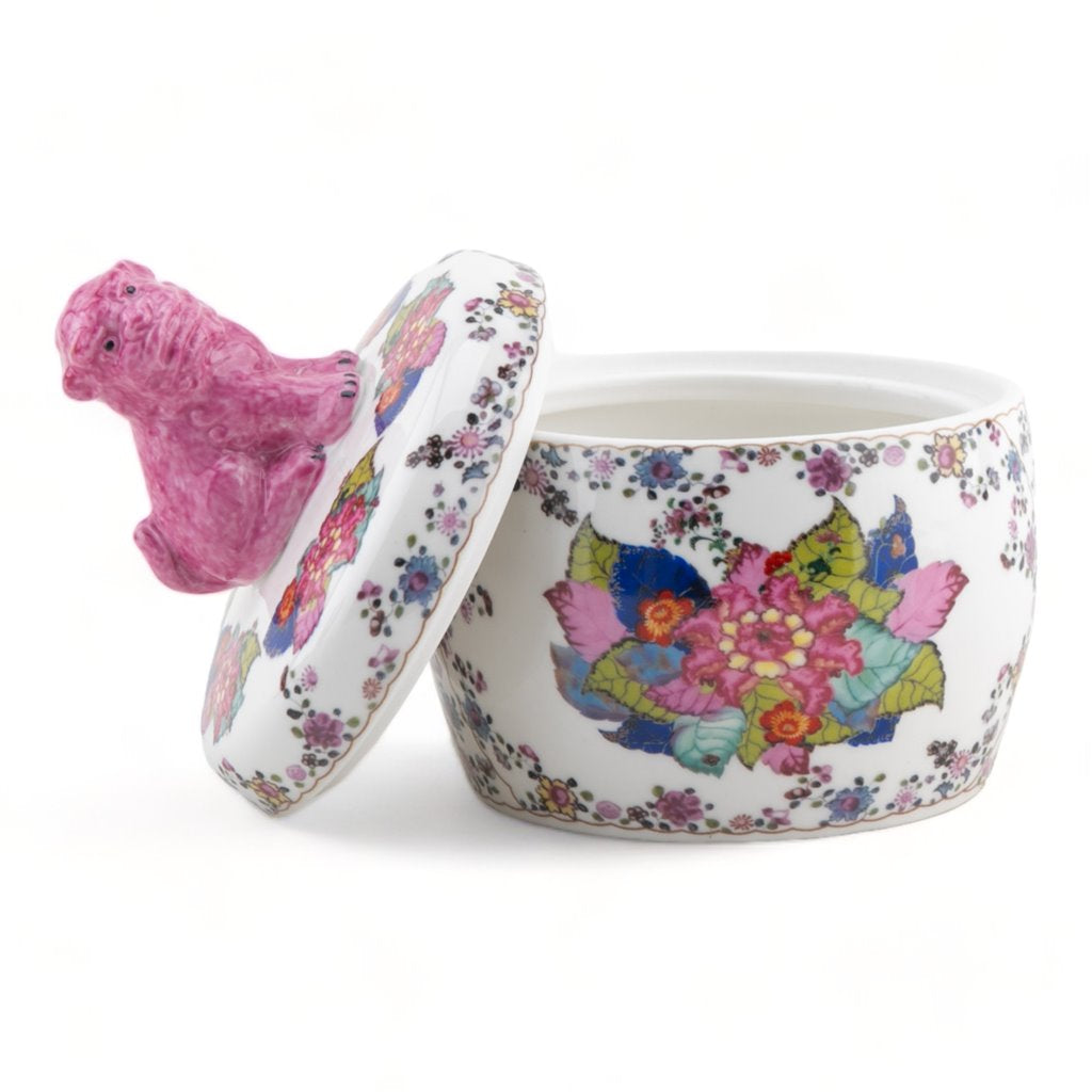 Decorative ceramic pot with floral design and pink lid on a white background