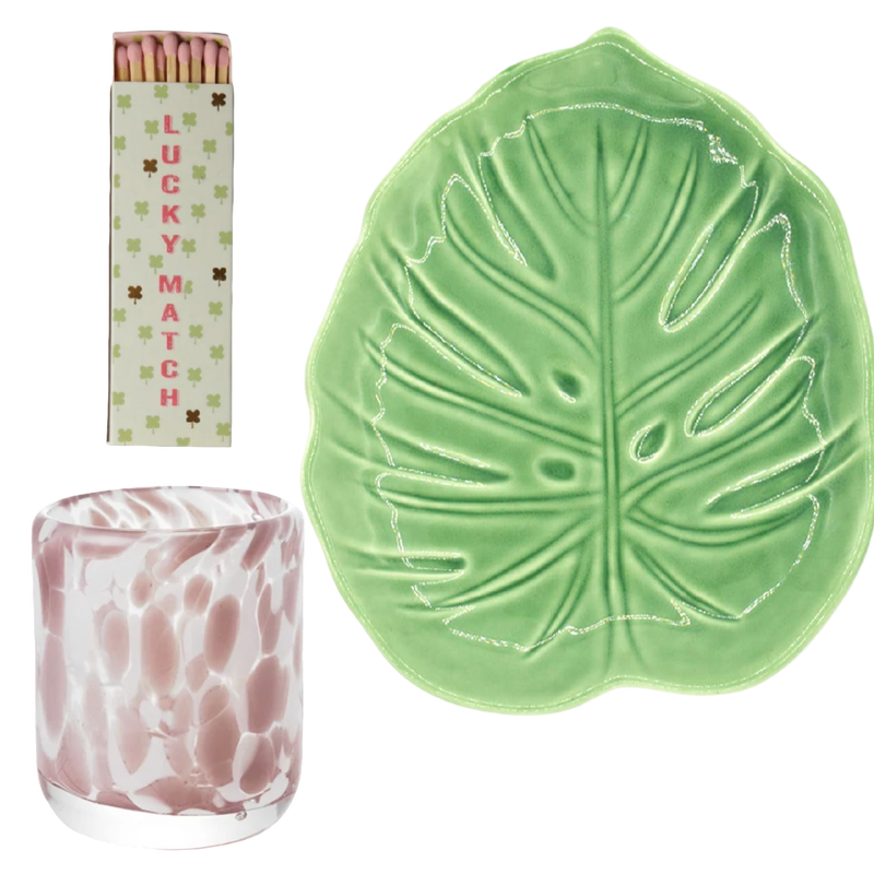 Green leaf-shaped dish, pink and white patterned candle, and 'Lucky Matches' packaging on a white background