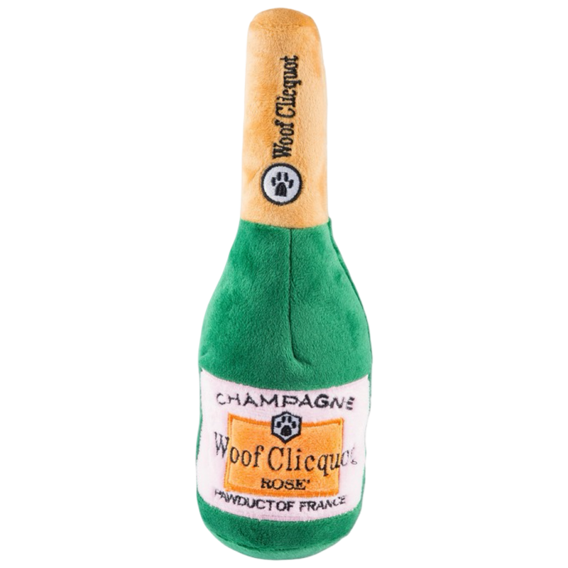 Plush toy shaped like a champagne bottle with 'Woof Clicquot' branding on a white background