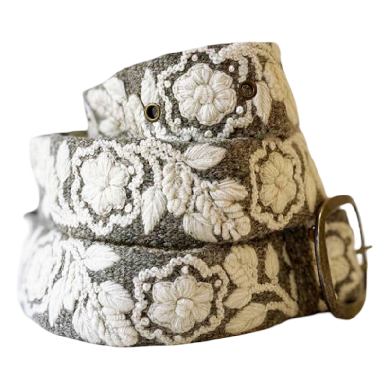 A woven belt with a textured gray base and raised off-white floral embroidery, finished with a brass buckle.