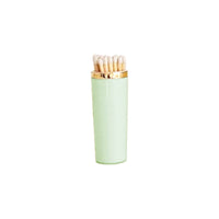 Light green matches with gold cap on a white background