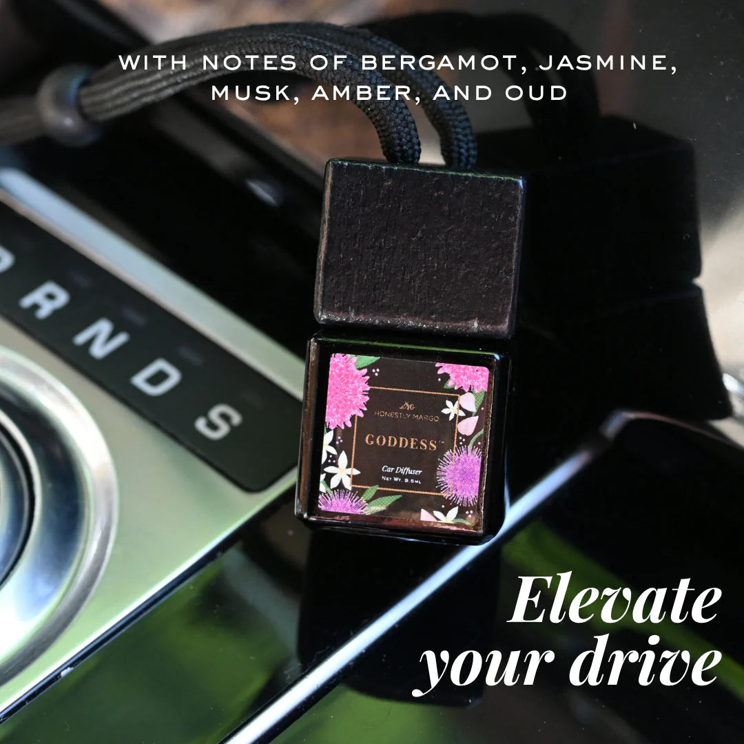 Car diffuser with floral design on a car dashboard, featuring notes of bergamot, jasmine, musk, amber, and oud.
