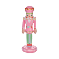 Decorative nutcracker figurine with pink outfit and striped pants on a white background