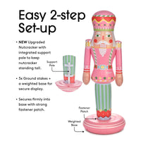 Inflatable nutcracker with support pole and ground stakes on a white background