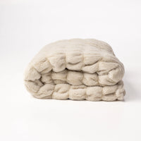 Stack of cream-colored yarn on a white background