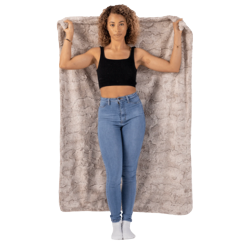 Woman holding a large gray blanket with a textured pattern on a white background