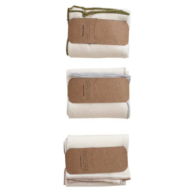 Three folded towels with brown labels on a white background