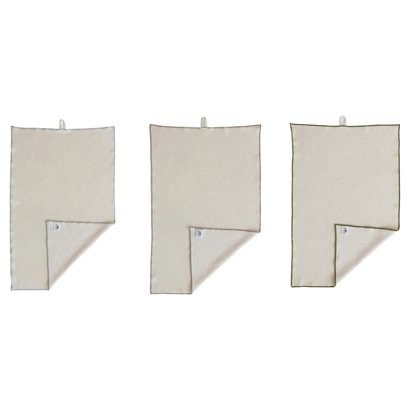 Three beige towels hanging on a white background