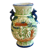 Decorative ceramic vase with cherubic figures and blue handles on a white background